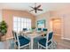 Dining room with white table and blue chairs, bathed in natural light from shuttered window at 12204 Coldstream Ln, Tampa, FL 33626