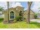 Charming home with lush front yard, arched window, and a two-car garage at 12204 Coldstream Ln, Tampa, FL 33626