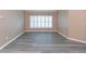 Neutral living room featuring gray floors and white shuttered windows at 12204 Coldstream Ln, Tampa, FL 33626