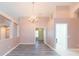 Spacious living area with gray wood floors, chandelier, and multiple doorways at 12204 Coldstream Ln, Tampa, FL 33626