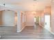 Spacious living area with gray wood floors, chandelier, and multiple doorways at 12204 Coldstream Ln, Tampa, FL 33626