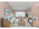 Bright living room with wicker furniture, blue accents, and natural light from the window at 12204 Coldstream Ln, Tampa, FL 33626