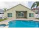 Swimming pool behind home with a brick-paved patio, showing beige exterior and green shutters at 12204 Coldstream Ln, Tampa, FL 33626