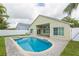 Backyard pool and spa with brick-paved patio, surrounded by green lawn and a beige exterior home at 12204 Coldstream Ln, Tampa, FL 33626