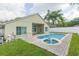 Backyard pool and spa with brick-paved patio and green lawn behind a beige exterior home at 12204 Coldstream Ln, Tampa, FL 33626
