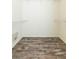 Spacious walk-in closet with white wire shelving and wood-look laminate flooring at 12204 Coldstream Ln, Tampa, FL 33626