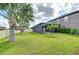 Well-maintained backyard showcases a screened-in pool, lush lawn, and mature trees with views of the water at 13111 Bahia Grass Ln, Riverview, FL 33579