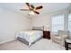 Comfortable bedroom includes a ceiling fan, a cozy chair, and natural light at 13111 Bahia Grass Ln, Riverview, FL 33579