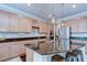 Stylish kitchen featuring an island with granite counters, custom cabinets, and modern appliances at 13111 Bahia Grass Ln, Riverview, FL 33579