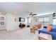Bright living room featuring carpet, ceiling fan, and a comfortable seating area at 13111 Bahia Grass Ln, Riverview, FL 33579
