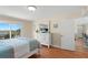 Bedroom with balcony access, dresser with TV, and warm lighting at 13440 Gulf Blvd # 202, Madeira Beach, FL 33708