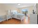 Bedroom featuring hardwood floors, queen bed, and balcony access at 13440 Gulf Blvd # 202, Madeira Beach, FL 33708