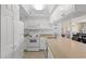 Compact kitchen with white cabinetry and appliances at 13440 Gulf Blvd # 202, Madeira Beach, FL 33708