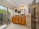 Bright bathroom featuring a walk-in shower with glass door, updated vanity, and granite countertop at 14175 Feather Sound Dr, Clearwater, FL 33762