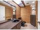 Modern bathroom featuring brown textured wall coverings, wood cabinetry, and black plumbing fixtures at 14175 Feather Sound Dr, Clearwater, FL 33762