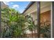 Inviting courtyard features lush landscaping and a decorative wood front door at 14175 Feather Sound Dr, Clearwater, FL 33762