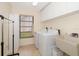 Bright laundry room featuring white appliances, a large utility sink, and ample storage at 14175 Feather Sound Dr, Clearwater, FL 33762