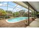 Inviting screened-in pool area with lush greenery, perfect for relaxing and enjoying the outdoors in privacy at 14175 Feather Sound Dr, Clearwater, FL 33762