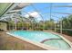 Screened-in pool with a connected spa, set in a beautifully landscaped outdoor area with clear blue skies at 14175 Feather Sound Dr, Clearwater, FL 33762