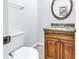 A half bathroom with an oval mirror, granite countertop, and wood cabinets at 15604 Deerglen Dr, Tampa, FL 33624