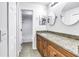 Bathroom with granite countertop, wood cabinets, and shower with tub behind a white door at 15604 Deerglen Dr, Tampa, FL 33624