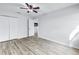 Clean bedroom with wood look flooring and white walls, has a ceiling fan and closet at 15604 Deerglen Dr, Tampa, FL 33624