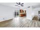 Bright, open living room with wood floors, ceiling fan, and sliding glass door to the backyard at 15604 Deerglen Dr, Tampa, FL 33624