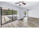 Open living area with wood-look flooring and multiple sliding glass doors leading to the pool area at 15604 Deerglen Dr, Tampa, FL 33624