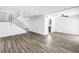 Bright living room with hardwood floors, modern ceiling fans, and a staircase with iron railing at 15604 Deerglen Dr, Tampa, FL 33624