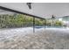 Spacious screened pool area with stone paver deck and covered porch features at 15604 Deerglen Dr, Tampa, FL 33624