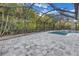A screened-in pool area features a stone paver deck, waterfall feature, and lush tropical landscaping at 15604 Deerglen Dr, Tampa, FL 33624