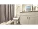 Cozy bathroom featuring a shower with gray curtain, toilet, and a modern vanity with granite countertops at 17015 Coral Key Dr, Nokomis, FL 34275
