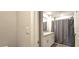 Neutral full bathroom with double sinks, cabinets, granite countertop, shower and gray shower curtain at 17015 Coral Key Dr, Nokomis, FL 34275