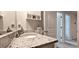A well-lit bathroom with granite countertop vanity, chrome faucet, and a mirror with a medicine cabinet and open door at 17015 Coral Key Dr, Nokomis, FL 34275
