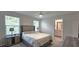 Neutral bedroom featuring carpet, ceiling fan, two windows, and an open door to the bathroom at 17015 Coral Key Dr, Nokomis, FL 34275