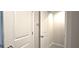 Hallway with a tiled floor, a towel rack, and two doors, one open, one closed at 17015 Coral Key Dr, Nokomis, FL 34275