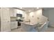This modern kitchen features white cabinets, granite countertops, stainless steel appliances and an island with bar seating at 17015 Coral Key Dr, Nokomis, FL 34275