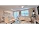 A well-lit living room features white couches, glass tables, and dining area with large windows and sliding doors at 17015 Coral Key Dr, Nokomis, FL 34275