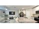 A bright, open-concept living room features a flat screen TV, white couches, glass tables, and an eat-in kitchen at 17015 Coral Key Dr, Nokomis, FL 34275