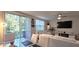 Bright living room and dining area with sliding glass doors leading to the backyard, white couches, and glass tables at 17015 Coral Key Dr, Nokomis, FL 34275