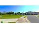 Road with a grassy lot, sidewalks, and houses in the background on a sunny day at 17015 Coral Key Dr, Nokomis, FL 34275