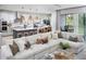 Open-concept living room with a large sectional sofa, kitchen view, and balcony access at 17420 Moonflower Dr # 203, Venice, FL 34293