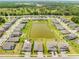 Aerial view of houses around a pond with green trees and well-maintained lawns at 17618 Cortes Creek Blvd, Spring Hill, FL 34610