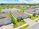 Lush aerial view showcasing the home's landscaped lawn and nearby pond at 17618 Cortes Creek Blvd, Spring Hill, FL 34610