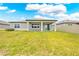 A spacious backyard featuring a covered porch and lush green lawn at 17618 Cortes Creek Blvd, Spring Hill, FL 34610