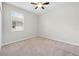 A bright bedroom features neutral walls, carpet, a ceiling fan, and a window with blinds at 17618 Cortes Creek Blvd, Spring Hill, FL 34610