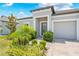 Home exterior with lush landscaping, leading to a welcoming front door and attached garage at 17618 Cortes Creek Blvd, Spring Hill, FL 34610