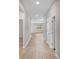 Clean hallway with neutral paint, wood-look floors, and access to various rooms at 17618 Cortes Creek Blvd, Spring Hill, FL 34610