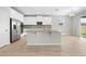 A modern kitchen with white cabinetry, stainless steel appliances, a mosaic backsplash, and a central island at 17618 Cortes Creek Blvd, Spring Hill, FL 34610