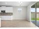 Kitchen and eat in area with stainless appliances, white cabinets, granite counters and view to back patio at 17618 Cortes Creek Blvd, Spring Hill, FL 34610